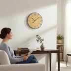 Standuhren.com 🕰️ AMS Wanduhr mit hellem Holzgehäuse und schwarzem Metallring an einer weißen Wohnzimmerwand