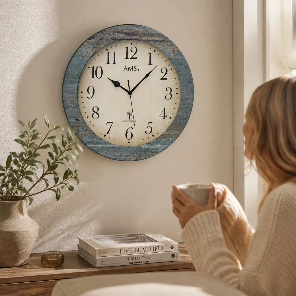 Standuhren.com 🕰️ AMS F5562 Funkwanduhr mit blauem Holzgehäuse und klassischem Zifferblatt in einem Wohnzimmer