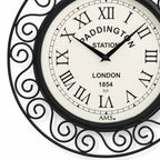 Standuhren.com 🕰️ AMS Funkwanduhr mit schwarzem Metallgehäuse, römischen Ziffern und Paddington Station Design